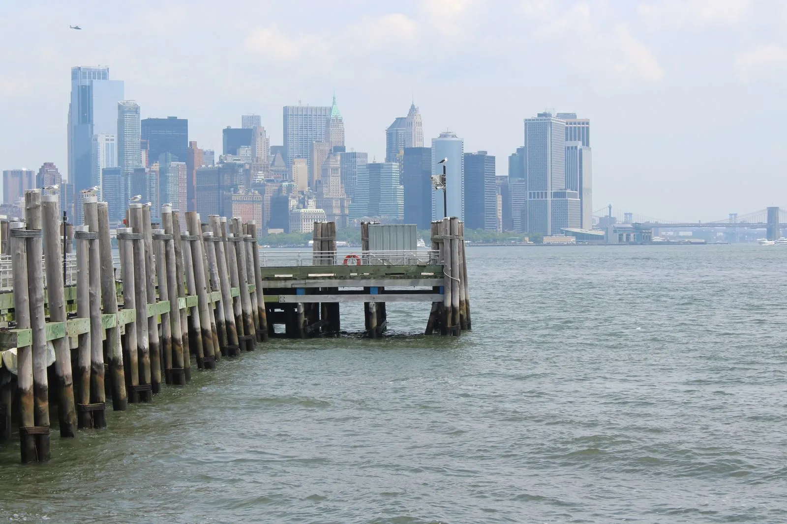 A tranquil view of the Manhattan skyline from a waterfront pier in New York City.